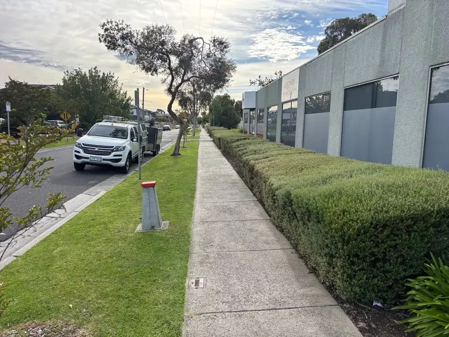 Commercial frontage hedge and footpath edge kept clear on a scheduled visit