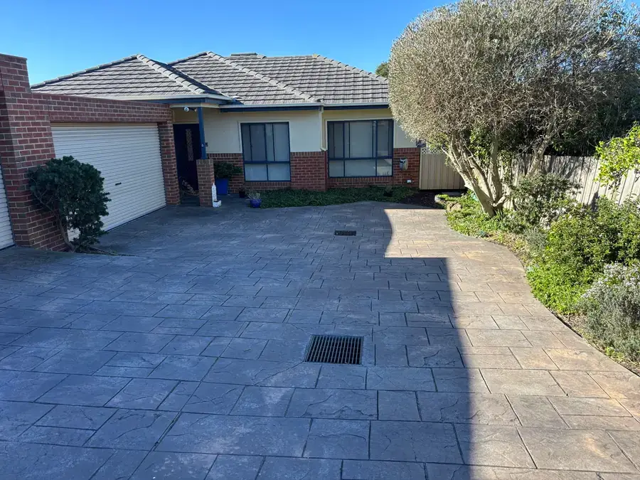 Townhouse frontage with maintained garden beds and mown common area lawn