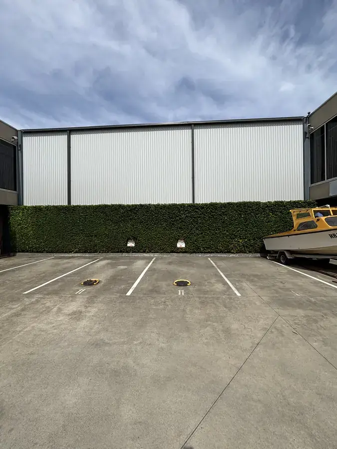 Commercial car park screening hedge and grounds maintained by Blue Hills in Braeside VIC